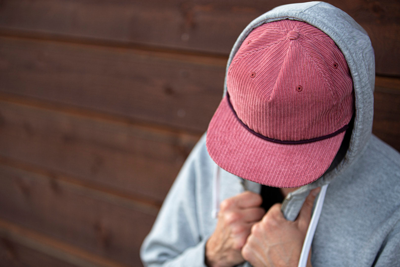 A man wearing a blank corduroy snapback with flat bill and rope in Garnet and Burgundy from Blvnk Headwear