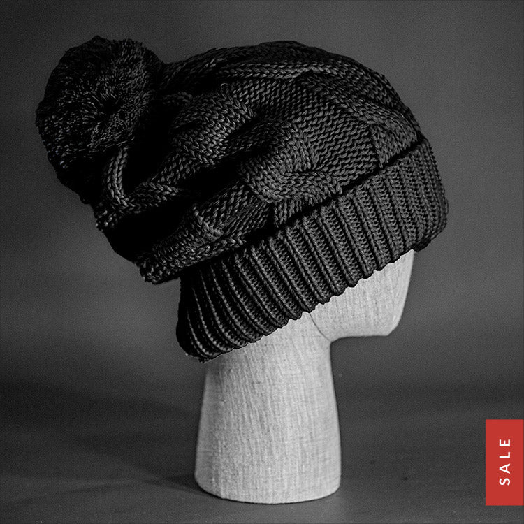 The Northstar Beanie, a black colored, extra long cable knit knit, blank beanie with oversized Pom Pom. Designed by Blvnk Headwear.