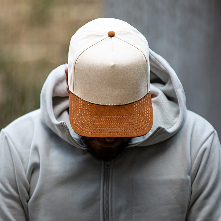 all-groups Blvnk Headwear Vision Vintage Shape Snapback Hat NATURAL BROWN SUEDE on man in grey hoodie.