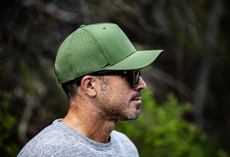 The Vanguard Blank Tech Snapback in burnt olive on man hiking in the Colorado mountains by Blvnk Headwear.