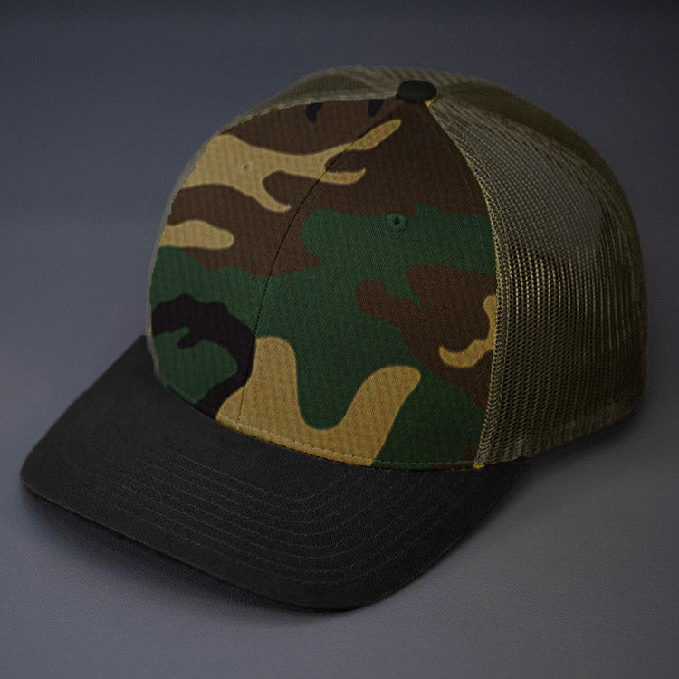 A Camo, Loden & Black, Cotton Twill, Mesh Backed, Blank Trucker Hat with a Pre Curved Bill, & Classic Snapback. | Designed by Blvnk Headwear