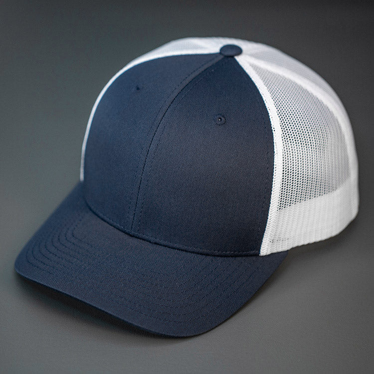 A Dark Navy & White, Cotton Twill, Mesh Backed, Blank Trucker Hat with a Pre Curved Bill, & Classic Snapback. | Designed by Blvnk Headwear