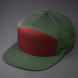 A Dark Cardinal & Military Olive colored, Cotton Twill, Blank 7 Panel Hat with a Flat Bill, Brass Details, & Vegan Leather Strapback. Designed by Blvnk Headwear