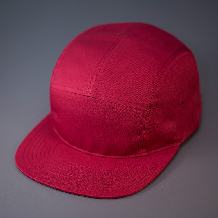 A Berry, Cotton Twill, Blank 5 Panel Camp Hat With a Flat Bill, & Woven Nylon Strapback. Designed by Blvnk Headwear