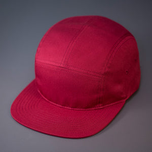 A Berry, Cotton Twill, Blank 5 Panel Camp Hat With a Flat Bill, & Woven Nylon Strapback.  Designed by Blvnk Headwear