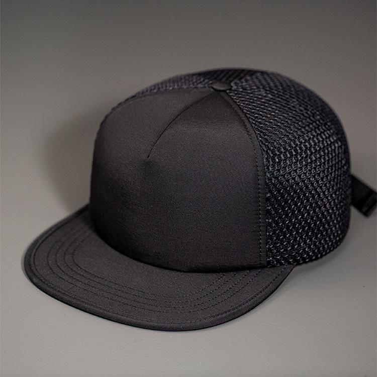 A Water Resistant Nylon, Blank Trucker Hat with a Packable Flotation Bill with a Hydro Mesh back & Woven Nylon Strapback. | Black Colorway by BLVNK Headwear.