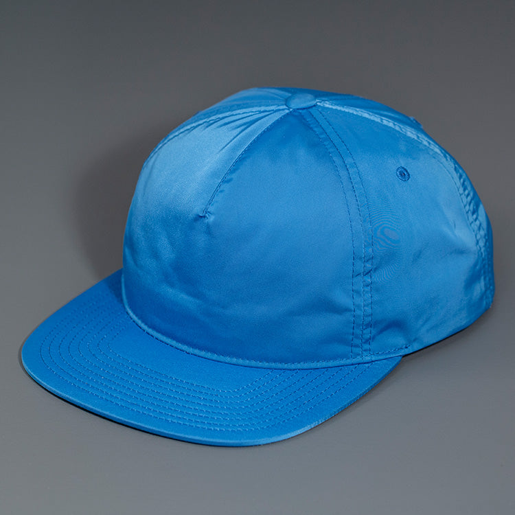 A Blue, Unstructured Satin Nylon, Blank Hat W/ a Pinch Front Crown, Flat Bill & a Classic Snapback. | Designed by Blvnk Headwear