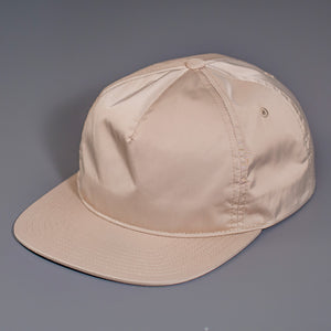 A Champagne colored, Unstructured Satin Nylon, Blank Hat W/ a Pinch Front Crown, Flat Bill & a Classic Snapback.  |  Designed by Blvnk Headwear