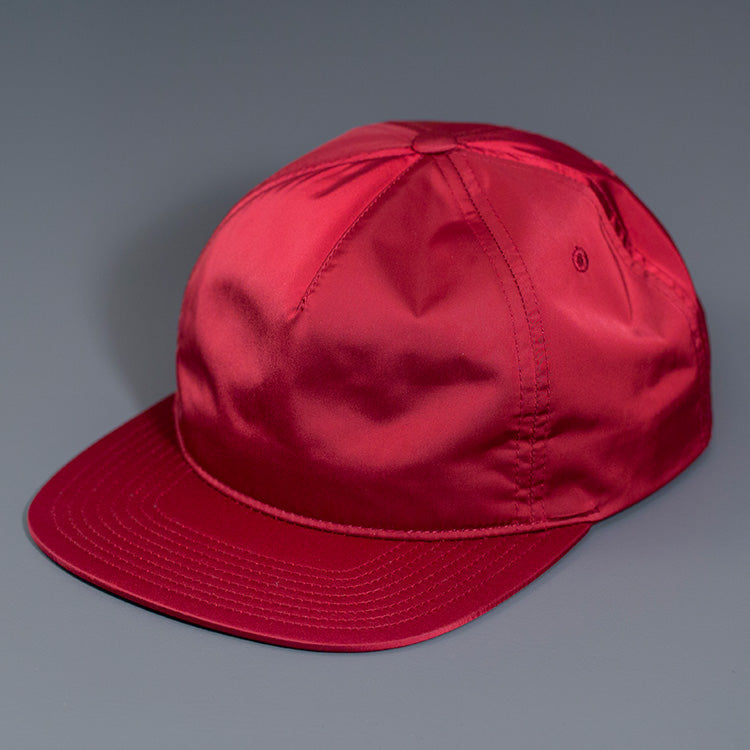 A Maroon Colored, Unstructured Satin Nylon, Blank Hat W/ a Pinch Front Crown, Flat Bill & a Classic Snapback. | Designed by Blvnk Headwear