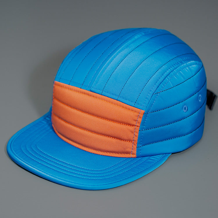 A Old Blue & Rust Quilted Nylon, Blank 5 Panel Camp Hat featuring a Packable Visor, Satin Lining & a Woven Nylon Backstrap. | Designed by Blvnk Headwear