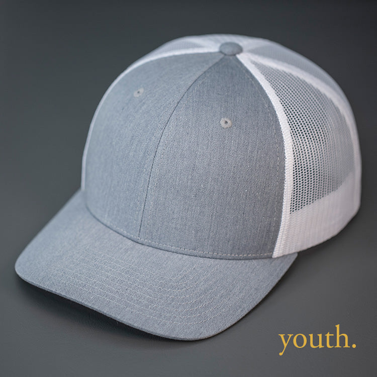 A Youth Sized, Heather Grey & White, Cotton Twill, Mesh Backed, Blank Trucker Hat with a Pre Curved Bill, & Classic Snapback. | Designed by Blvnk Headwear