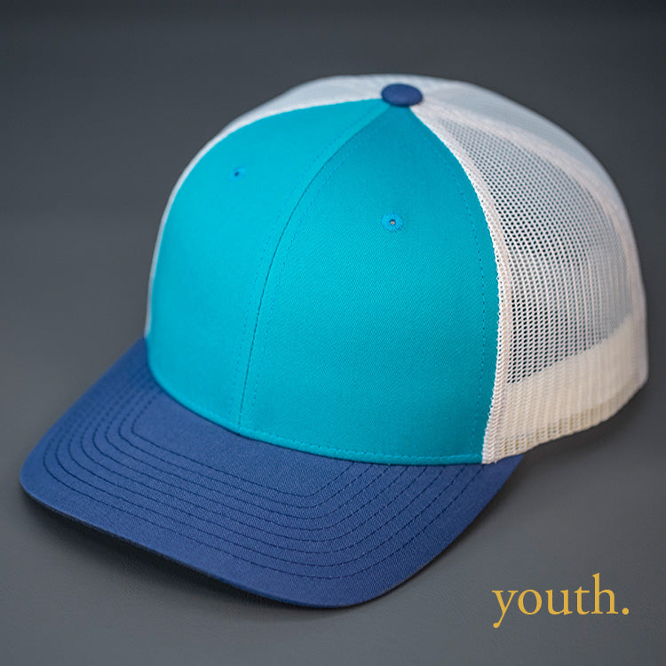 A Youth Sized, Teal, Birch & Light Navy, Cotton Twill, Mesh Backed, Blank Trucker Hat with a Pre Curved Bill, & Classic Snapback. | Designed by Blvnk Headwear