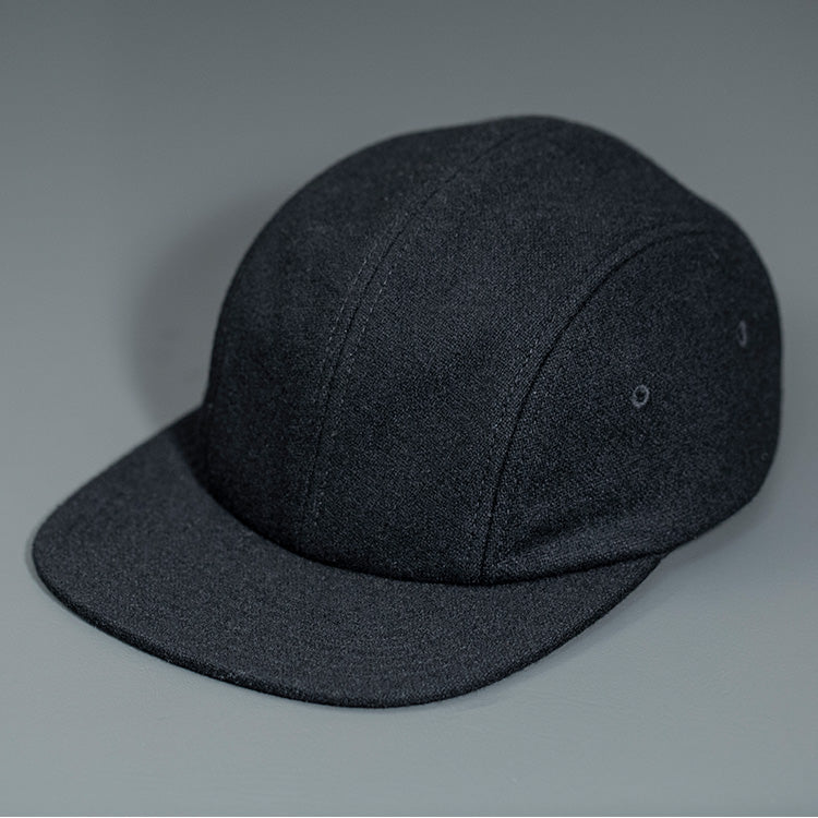 A Black, Melton Wool, Blank 4 Panel Hat with a Flat Bill, & Vegan Leather Strapback. Designed by Blvnk Headwear.