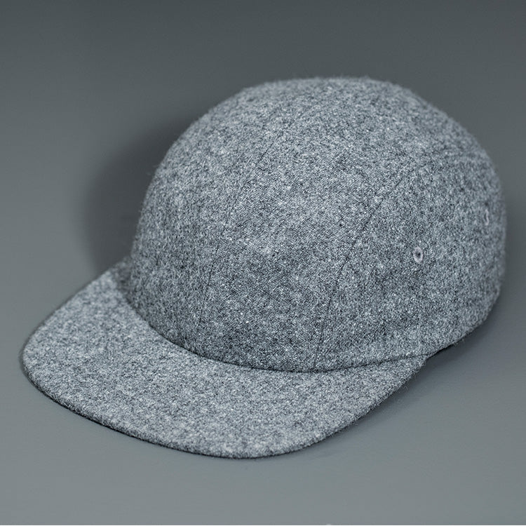 A Heather Grey, Melton Wool, Blank 4 Panel Hat with a Flat Bill, & Vegan Leather Strapback. Designed by Blvnk Headwear.