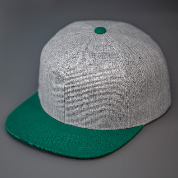 A Heather Grey & Green, Wool, 6 Panel, Flat Bill, Blank Snapback. Designed by Blvnk Headwear.