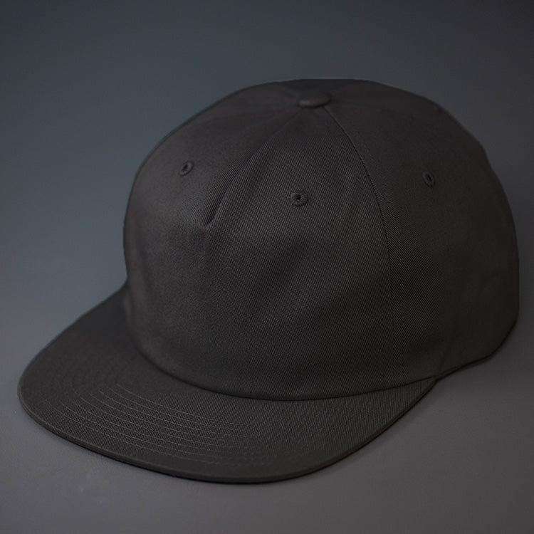 A Black, Unstructured, Premium Cotton, Blank Pinch Front Hat With a Vegan Leather Back Strap & Brass Clasp. Designed By Blvnk Headwear.