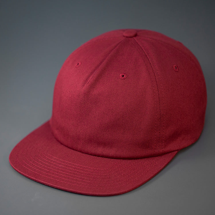 A Pale Maroon, Unstructured, Premium Cotton, Blank Pinch Front Hat With a Vegan Leather Back Strap & Brass Clasp. Designed By Blvnk Headwear.