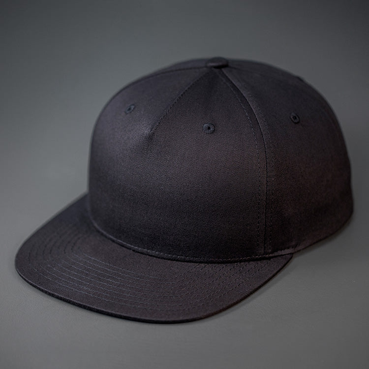A Black, Cotton Twill, Pinch Front, Blank Snapback Hat. Designed & Manufactured by Blvnk Headwear.
