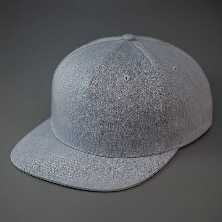 A Heather Grey Colored, Cotton Twill, Pinch Front, Blank Snapback Hat. Designed & Manufactured by Blvnk Headwear.