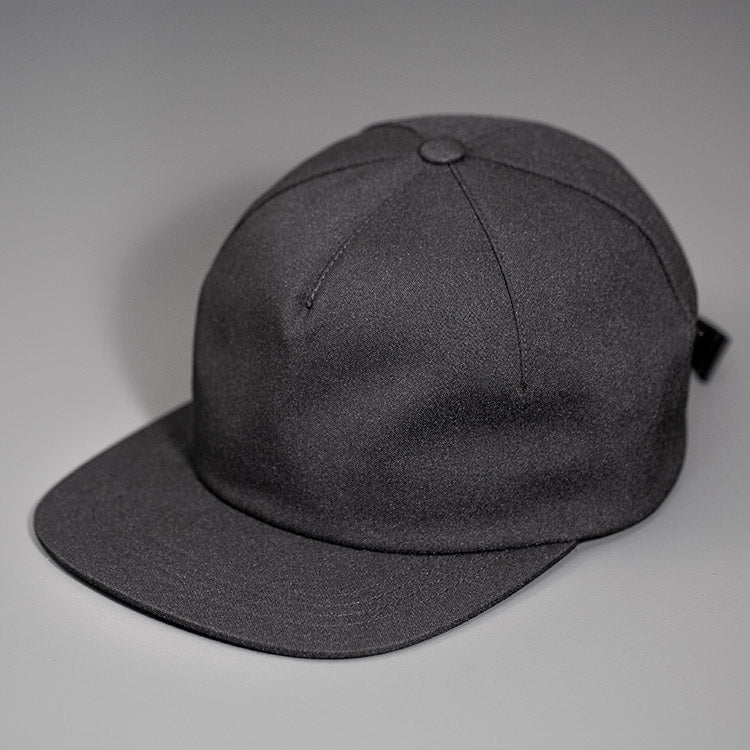 A Black Chambray, Blank 1 Panel Hat, W/ a Flat Bill & Woven Nylon Strapback. Designed by Blvnk Headwear.