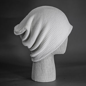 A white colored, super slouch knit blank beanie.  Designed by Blvnk Headwear.