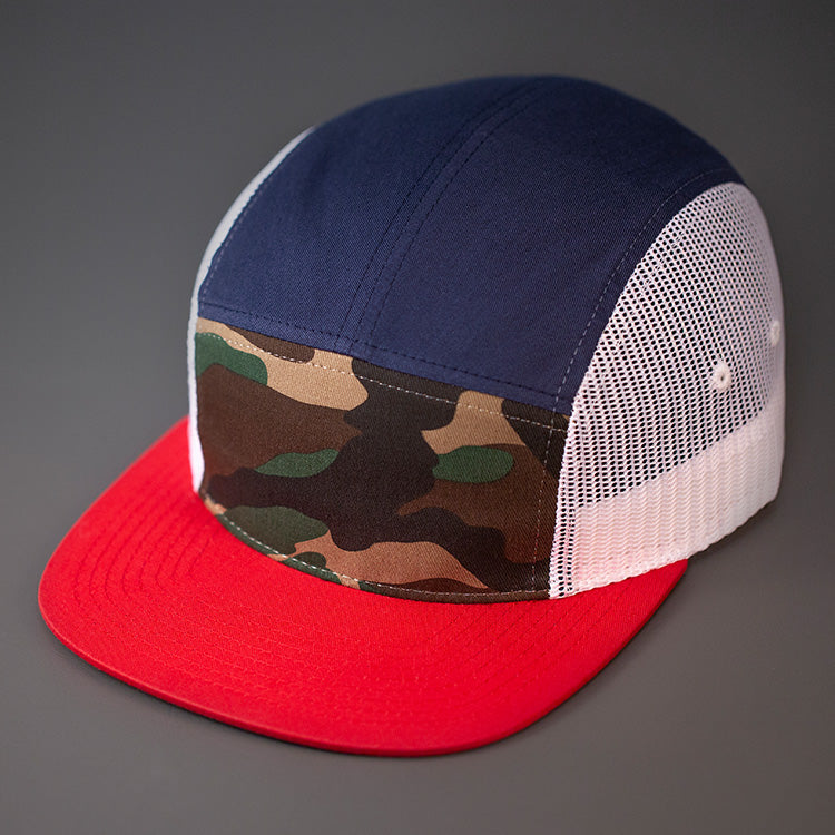 A Camo, Navy, White & Red, Cotton Twill/Mesh, Blank 5 Panel Camp Trucker Hat With a Flat Bill, & Woven Nylon Strapback. Designed by Blvnk Headwear.