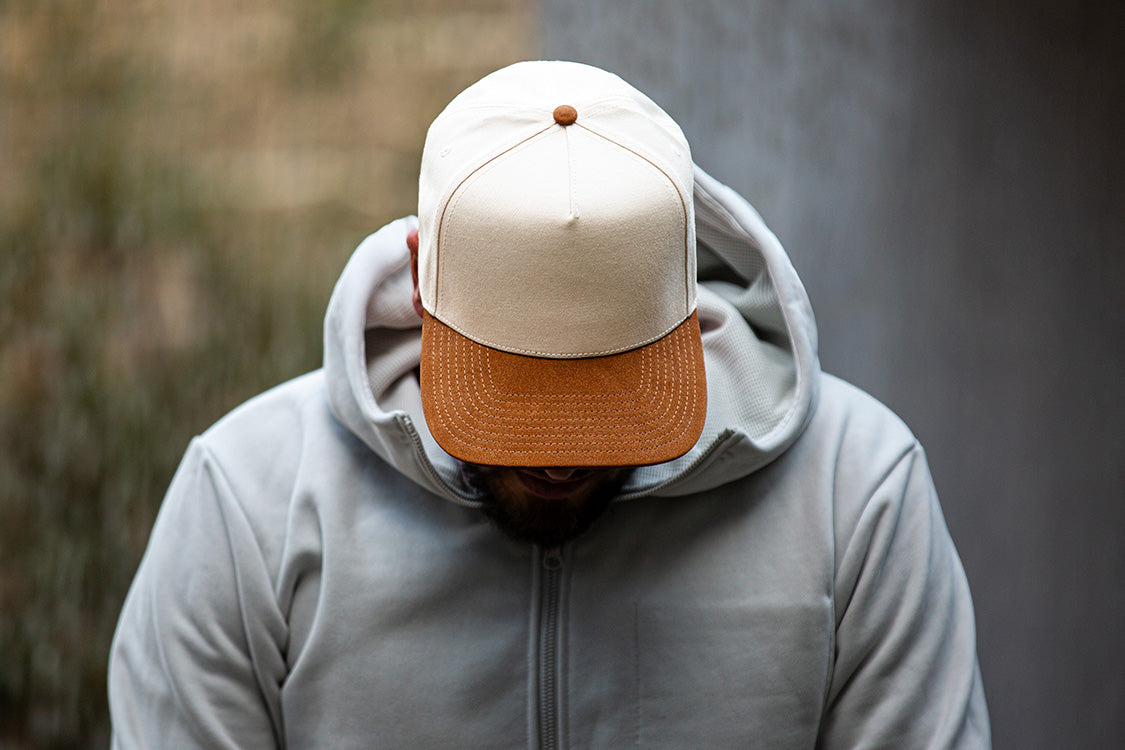 all-groups Blvnk Headwear Vision Vintage Shape Snapback Hat NATURAL BROWN SUEDE on man in grey hoodie.