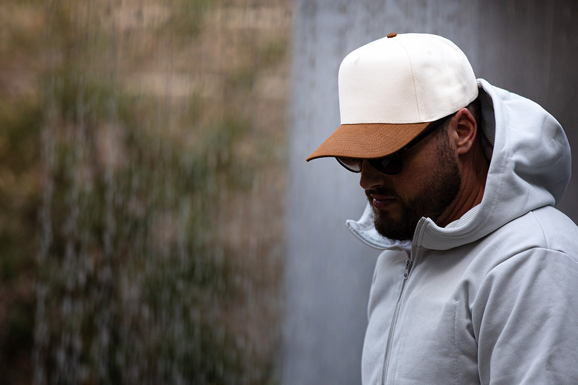 all-groups Blvnk Headwear Vision Vintage Shape Snapback Hat NATURAL BROWN SUEDE on man in hooded sweatshirt.