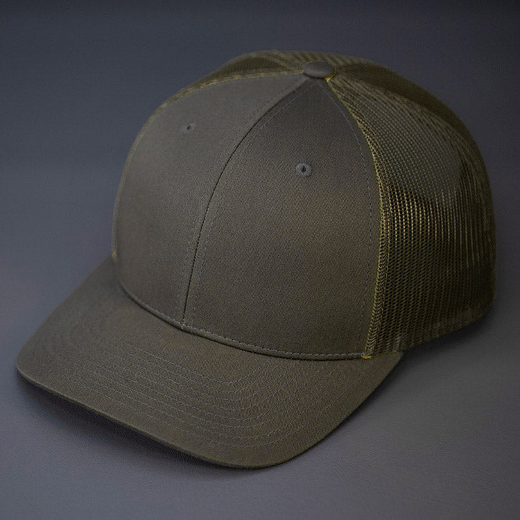 A Dark Loden & Loden, Cotton Twill, Mesh Backed, Blank Trucker Hat with a Pre Curved Bill, & Classic Snapback. | Designed by Blvnk Headwear
