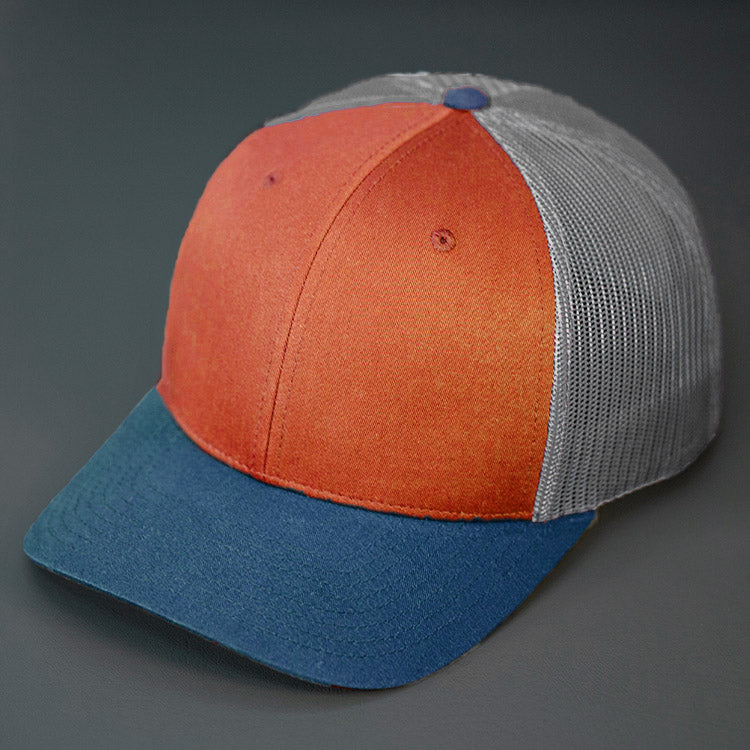 A Dark Orange, Aluminum & Light Navy, Cotton Twill, Mesh Backed, Blank Trucker Hat with a Pre Curved Bill, & Classic Snapback. | Designed by Blvnk Headwear