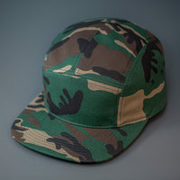 A Camo, Cotton Twill, Blank 5 Panel Camp Hat With a Flat Bill, & Woven Nylon Strapback.  Designed by Blvnk Headwear