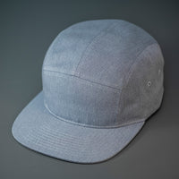 A Heather Grey, Cotton Twill, Blank 5 Panel Camp Hat With a Flat Bill, & Woven Nylon Strapback.  Designed by Blvnk Headwear.
