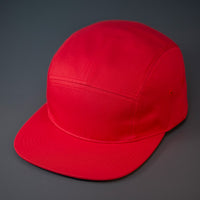A Red, Cotton Twill, Blank 5 Panel Camp Hat With a Flat Bill, & Woven Nylon Strapback.  Designed by Blvnk Headwear.