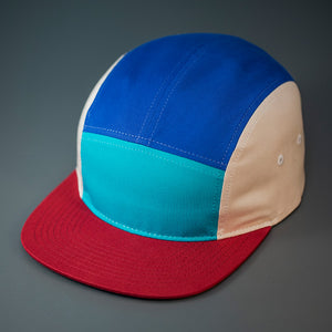 A Teal front, Blue Ribbon top, Birch sided, Cotton Twill, Blank 5 Panel Camp Hat With a Flat, Dark Cardinal Bill, & Woven Nylon Strapback.  Designed by Blvnk Headwear.