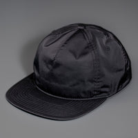A Black, Unstructured Satin Nylon, Blank Hat W/ a Pinch Front Crown, Flat Bill & a Classic Snapback.  |  Designed by Blvnk Headwear
