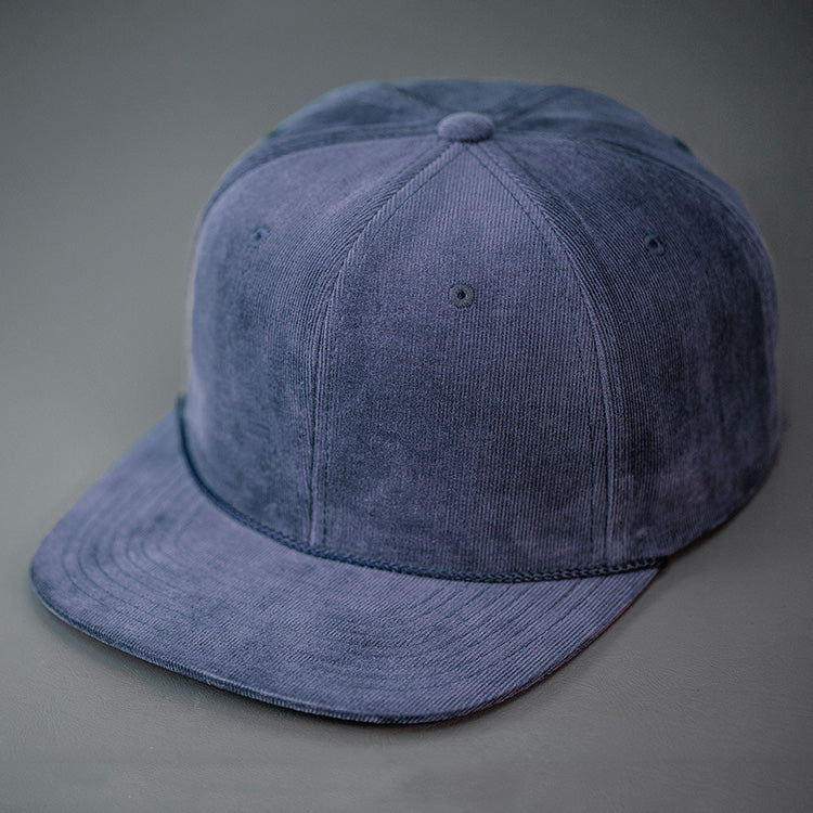 A Navy Corduroy, Blank 6 Panel Hat, with a Flat Bill & Classic Snapback  |  Designed by Blvnk Headwear
