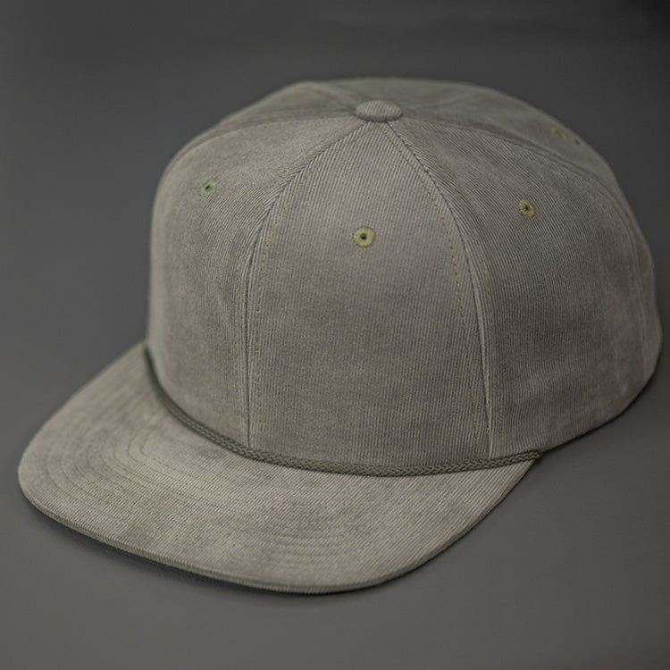 An Olive Corduroy, Blank 6 Panel Hat, with a Flat Bill & Classic Snapback  |  Designed by Blvnk Headwear