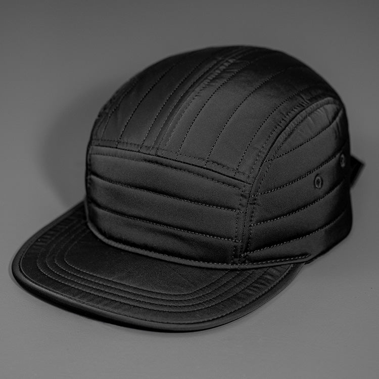 A Black Quilted Nylon, Blank 5 Panel Camp Hat featuring a Packable Visor, Satin Lining & a Woven Nylon Backstrap.  |  Designed by Blvnk Headwear
