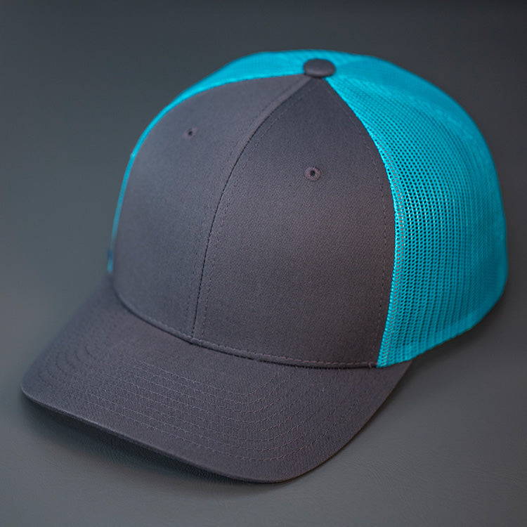 A Charcoal & Teal, Cotton Twill, Mesh Backed, Blank Trucker Hat with a Pre Curved Bill, & Classic Snapback.  |  Designed by Blvnk Headwear