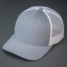 A Heather Grey & White, Cotton Twill, Mesh Backed, Blank Trucker Hat with a Pre Curved Bill, & Classic Snapback.  |  Designed by Blvnk Headwear