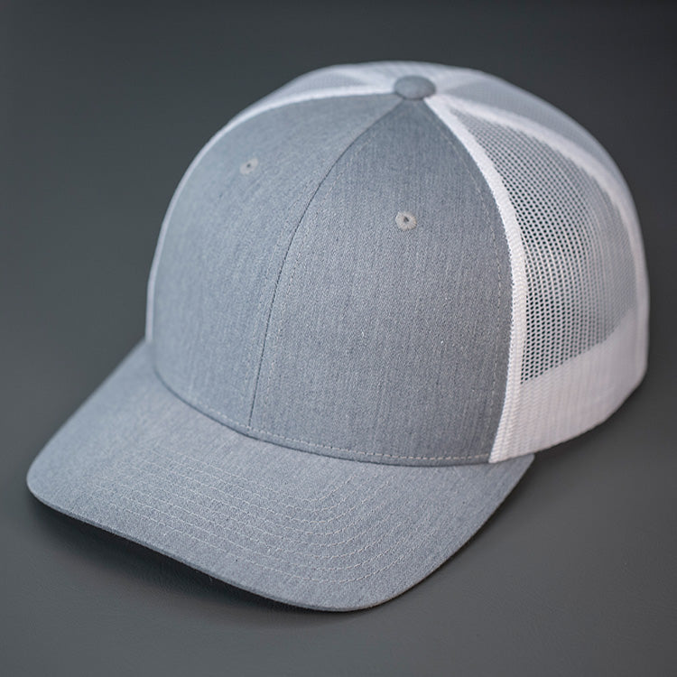 A Heather Grey & White, Cotton Twill, Mesh Backed, Blank Trucker Hat with a Pre Curved Bill, & Classic Snapback.  |  Designed by Blvnk Headwear