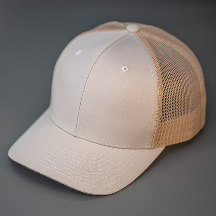 A Tan, Cotton Twill, Mesh Backed, Blank Trucker Hat with a Pre Curved Bill, & Classic Snapback.  |  Designed by Blvnk Headwear