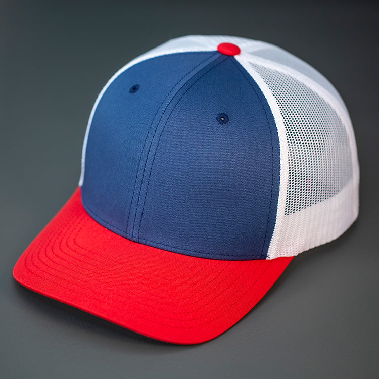 A Light Navy, White & Red, Cotton Twill, Mesh Backed, Blank Trucker Hat with a Pre Curved Bill, & Classic Snapback.  |  Designed by Blvnk Headwear