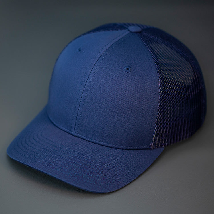 A Navy, Cotton Twill, Mesh Backed, Blank Trucker Hat with a Pre Curved Bill, & Classic Snapback.  |  Designed by Blvnk Headwear