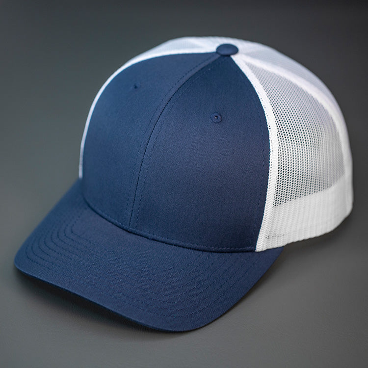 A Navy & White, Cotton Twill, Mesh Backed, Blank Trucker Hat with a Pre Curved Bill, & Classic Snapback.  |  Designed by Blvnk Headwear