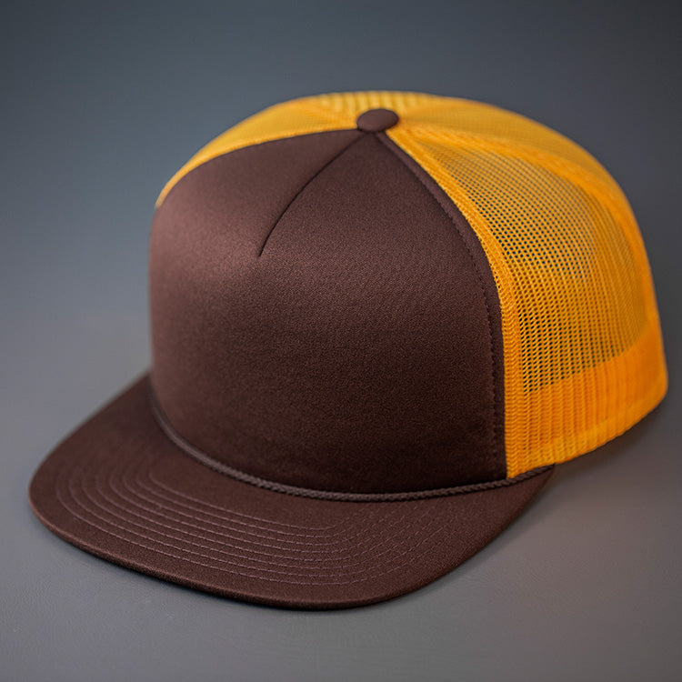 A Brown & Gold, Foam Front, Mesh Backed Blank Trucker Hat with a Flat Bill, & Classic Snapback.  Designed by Blvnk Headwear.
