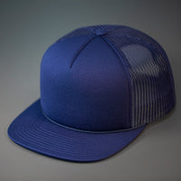 A Navy, Foam Front, Mesh Backed Blank Trucker Hat with a Flat Bill, & Classic Snapback.  Designed by Blvnk Headwear.