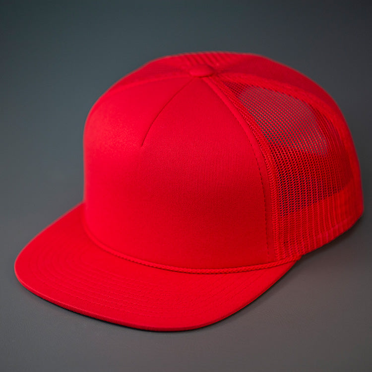 A Red, Foam Front, Mesh Backed Blank Trucker Hat with a Flat Bill, & Classic Snapback.  Designed by Blvnk Headwear.