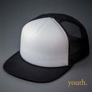 A Youth Sized, White & Black, Foam Front, Mesh Backed Blank Trucker Hat with a Flat Bill, & Classic Snapback.  Designed by Blvnk Headwear.