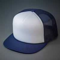 A White & Navy, Foam Front, Mesh Backed Blank Trucker Hat with a Flat Bill, & Classic Snapback.  Designed by Blvnk Headwear.